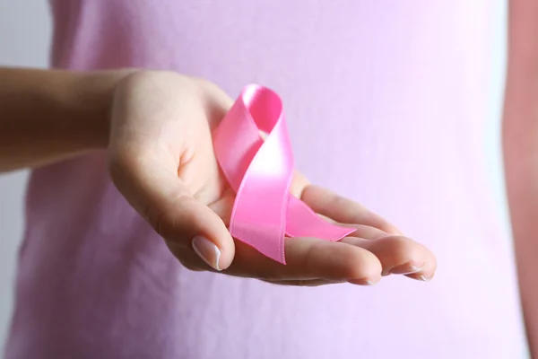 Pink ribbon in woman's hands — Stock Photo, Image