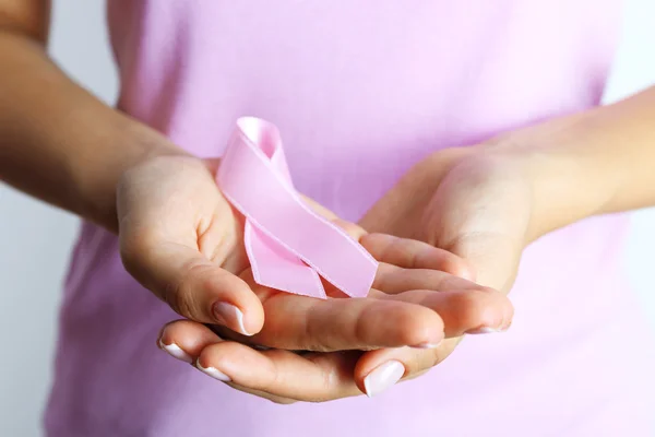 Pink ribbon in woman's hands — Stock Photo, Image