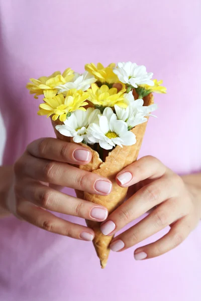 ワッフル コーンで花を持つ女性をクローズ アップ — ストック写真