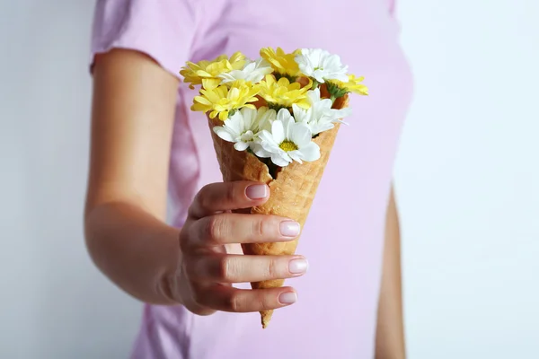 Mulher segurando flores em cones waffle, close-up — Fotografia de Stock