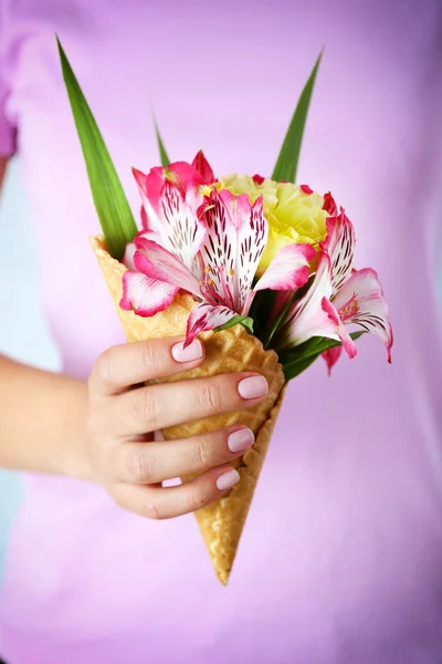 Жінка тримає дикі квіти у вафлі крупним планом — стокове фото