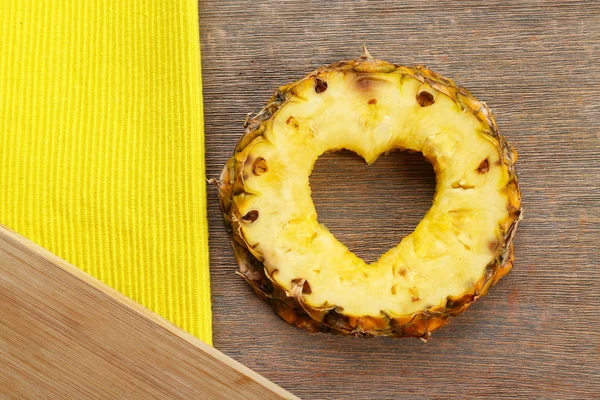 Ananas dilim ile ahşap arka plan üzerinde kalp şeklinde kesilmiş — Stok fotoğraf