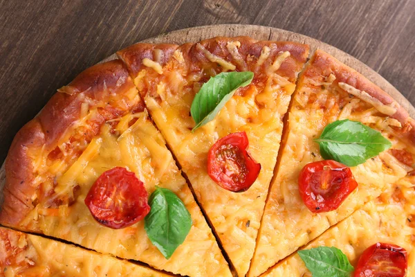 Ízletes sajtos pizza, bazsalikomos koktélparadicsommal, a táblázat szelet közelről — Stock Fotó