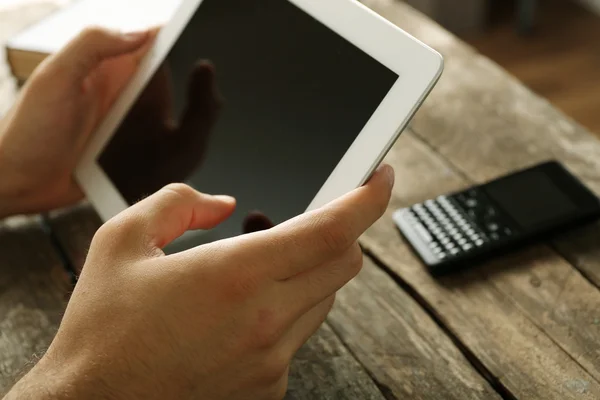 Hands holding digital tablet on wooden table background — Stock Photo, Image