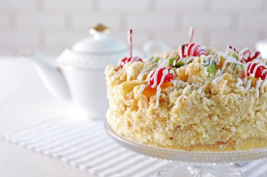 Tereyağı kek kiraz stand ve ışık arka plan üzerinde tablo ayarı ile