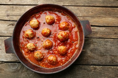 Ahşap arka plan üzerinde domates soslu köfte ile pan