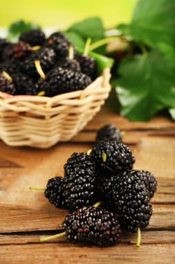 Ahşap masa, closeup üzerinde hasır sepet içinde taze dut
