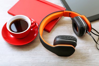 Tablet ve kahve ahşap masa üzerinde kulaklık yakın çekim