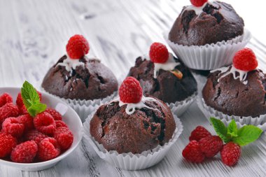 Çilek ve ahşap masa üzerinde taze nane ile lezzetli çikolata cupcakes yakın çekim