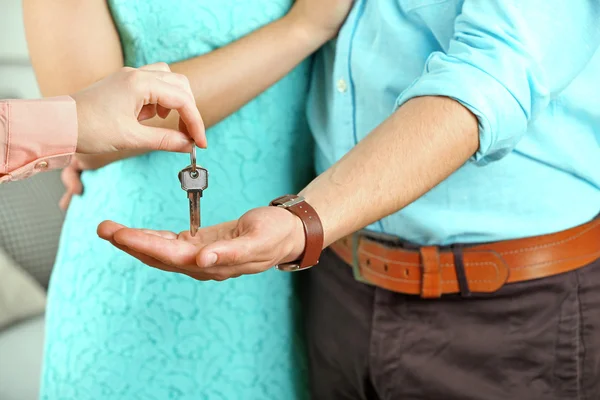 Onroerende goederenagent sleutels geven jong koppel — Stockfoto