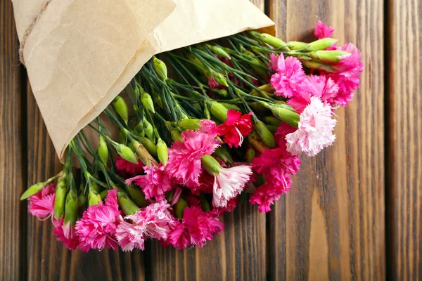 Beautiful bouquet of pink carnation on wooden table close up — Stock Photo, Image