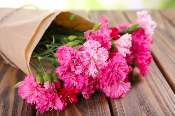 Beautiful bouquet of pink carnation on wooden table close up — Stock Photo, Image