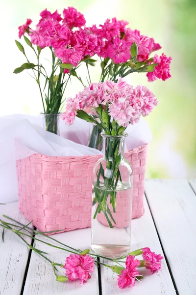 Beautiful bouquet of pink carnation in vases on bright background — Stock Photo, Image