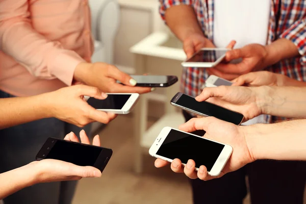 Muchas manos sosteniendo los teléfonos móviles de cerca —  Fotos de Stock