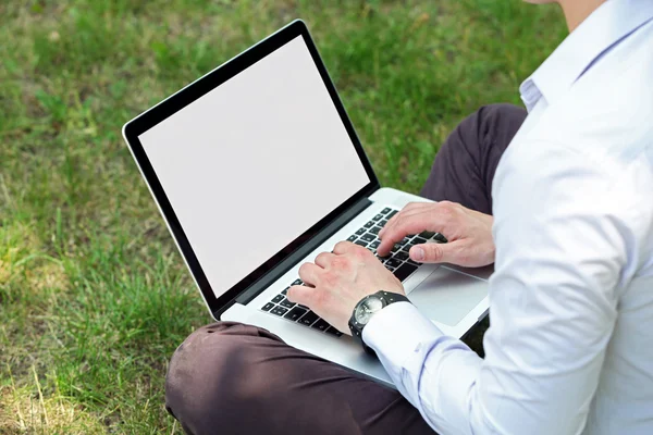 Jeune homme avec ordinateur portable à l'extérieur — Photo