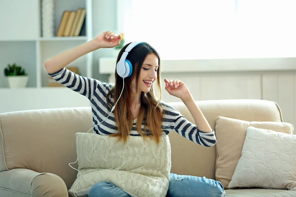 Woman listening music in headphones in room — Stock Photo, Image