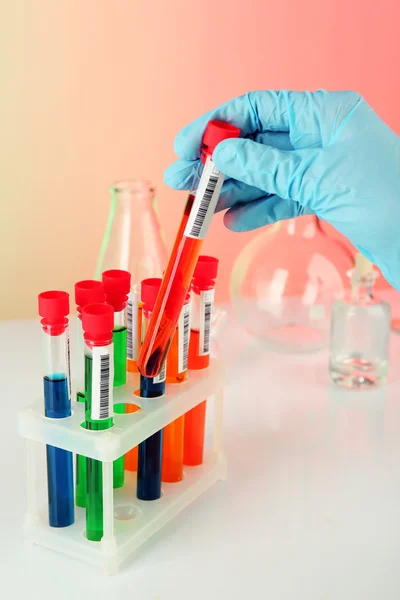 Test tubes with colorful liquid in scientist hand, closeup — Stock Photo, Image