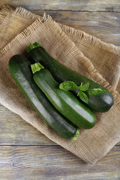 Fresh zucchini with basil on wooden table close up — Stock Photo, Image