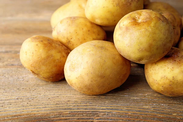 Batatas jovens na mesa de madeira perto — Fotografia de Stock