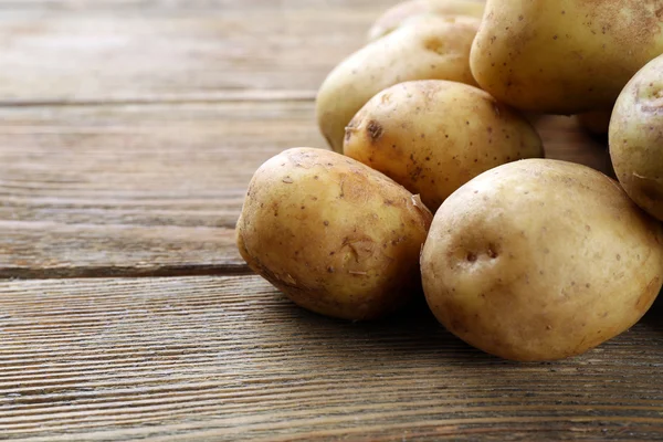 Batatas jovens na mesa de madeira perto — Fotografia de Stock