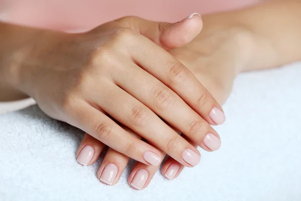 Vrouw handen met Frans manicure op handdoek close-up — Stockfoto