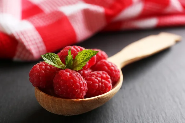 Frische rote Himbeeren in Löffel auf Holztisch, Nahaufnahme — Stockfoto