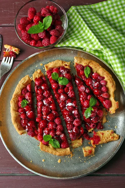 Tarta con frambuesas en bandeja, sobre fondo de madera — Foto de Stock