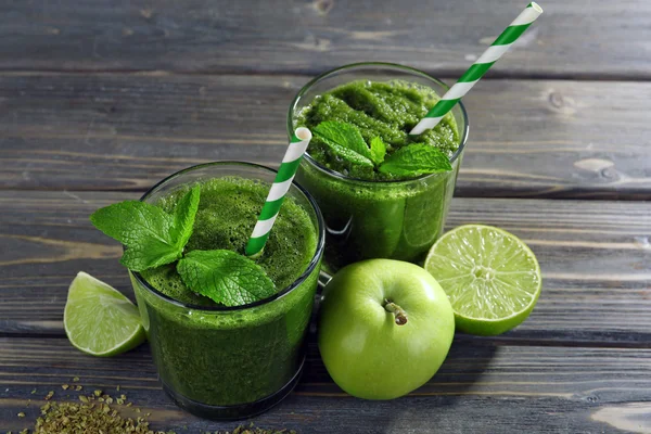 Succo sano verde con frutta e menta sul tavolo di legno da vicino — Foto Stock