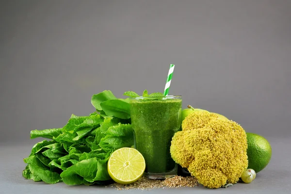 Groene gezond vruchtensap met groenten en fruit op grijze achtergrond — Stockfoto