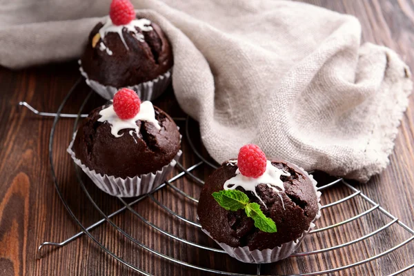 Deliziosi cupcake al cioccolato con bacche e menta fresca sul tavolo da vicino — Foto Stock