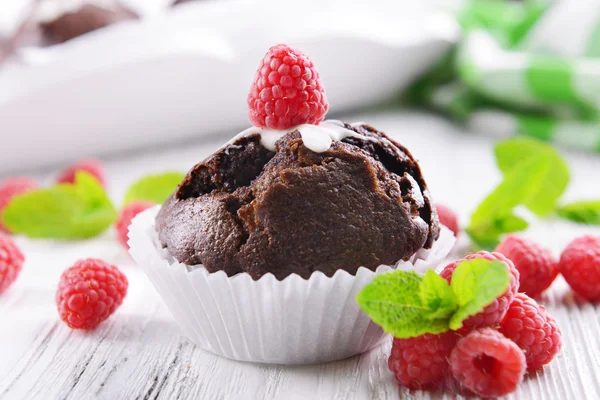 Läcker choklad cupcake med bär på träbord nära håll — Stockfoto