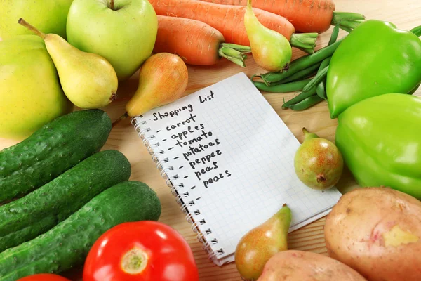 Hoop van fruit en groenten met boodschappenlijstje op tafel close-up — Stockfoto