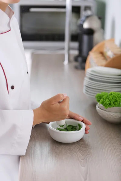 Kucharz ręce z zaprawy z ziołami na jasnym tle — Zdjęcie stockowe