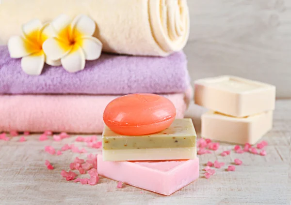 Barras de jabón natural y toallas de colores sobre fondo claro — Foto de Stock