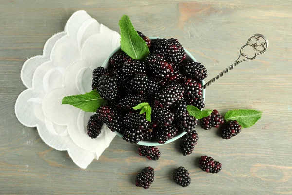 Heap of sweet blackberries with mint in bowl on table close up — Stock Photo, Image