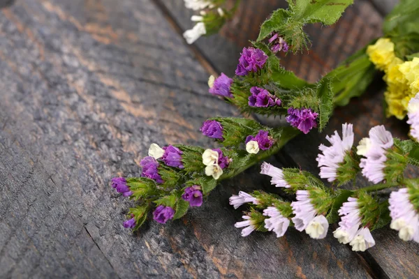 Vackra vilda blommor på träbord nära håll — Stockfoto