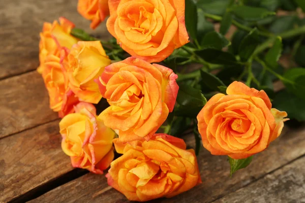 Schöne kleine Rosen auf Holztisch aus nächster Nähe — Stockfoto