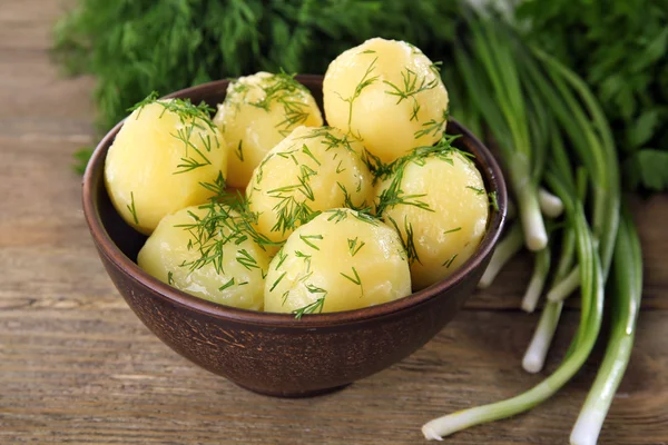 Las patatas cocidas con la verdura en la escudilla a la mesa se acercan —  Fotos de Stock