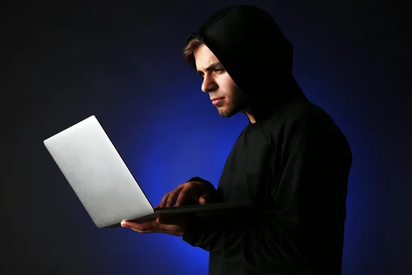 Hacker with computer and laptop on colorful dark background — Stock Photo, Image