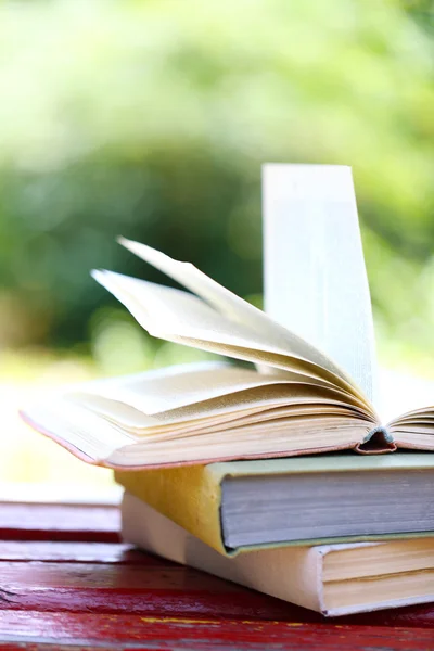 Bücherstapel im Freien, auf verschwommenem Hintergrund — Stockfoto