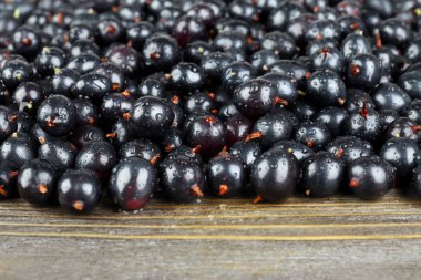 Ahşap masa üzerinde vahşi Siyah frenk üzümü yığını kapat