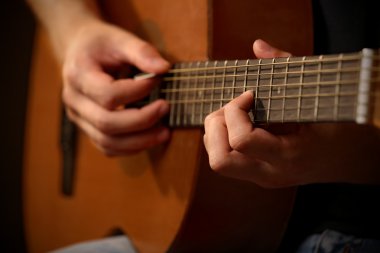 Genç müzisyen akustik gitar çalmak yakın çekim