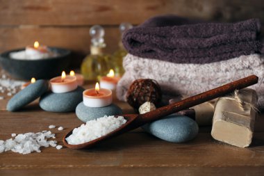 Ahşap zemin üzerinde mumlar olan güzel bir spa kompozisyonu.