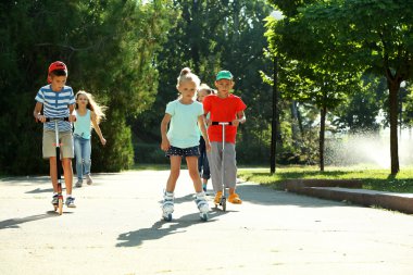 Çocuk scooter ve tekerlekli paten parkta sürme