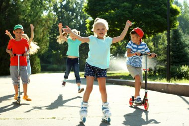 Çocuk scooter ve tekerlekli paten parkta sürme