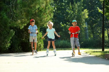 Çocuk scooter ve tekerlekli paten parkta sürme