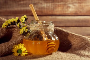 Kavanoz bal tutuyordu, çiçekler ile yakın çekim