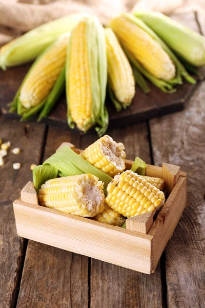 Frisches Mais auf Maiskolben in Kiste auf Holztisch, Nahaufnahme — Stockfoto