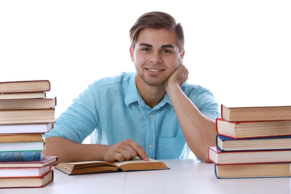 A fiatalember olvasókönyv asztalnál fehér háttér — Stock Fotó
