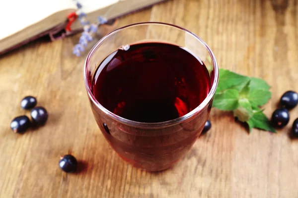 Jugo de grosella fresca con bayas y libro en la mesa de cerca — Foto de Stock